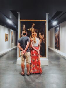 man and woman standing facing on man wearing brown robe suit photo